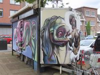 908261 Afbeelding van een gesloten bloemenwagen (?), met enkele graffitikunstwerken, op het Oppenheimplein te Utrecht.